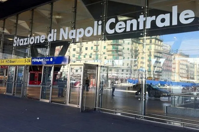 The glass entrance of Napoli Centrale station with its name sign
